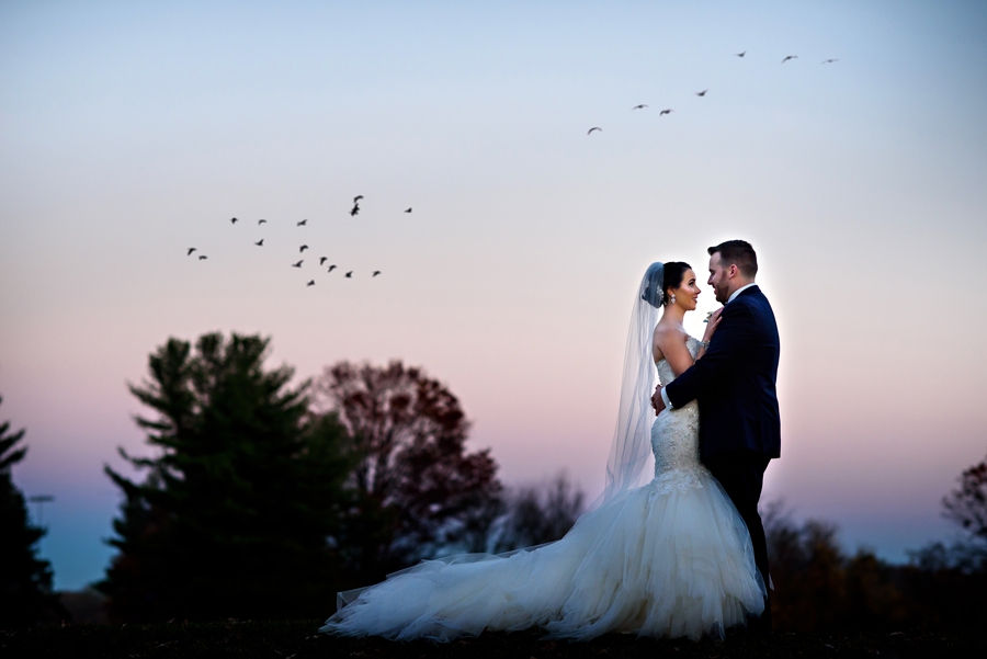 A bride and groom hug in the sunset on the golf course of Northampton Valley Country Club.